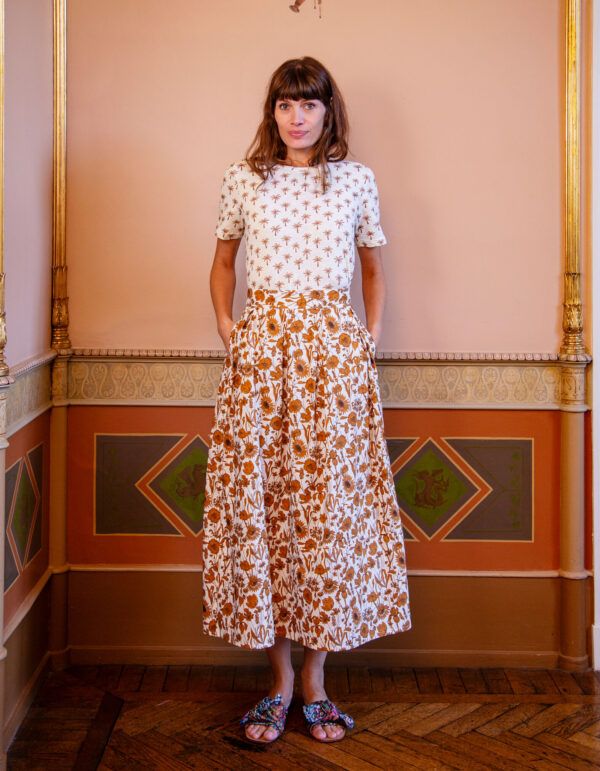 Baria Skirt - Mono Muse fra Apof. Baria Nederdel i Mono Muse har et poetisk, næsten illustrativt udtryk med et Liberty blomsterprint i varme, gyldne nuancer. Baria falder let og elegant med bløde læg, lukkes med lynlås i siden og giver silhuetten et roligt, feminint flow. Baria Nederdel i Mono Muse er en hyldest til detaljen - et Liberty blomsterprint, der folder sig ud som en håndtegnet fortælling i varme, afstemte toner. Det tætte mønster skaber dybde og bevægelse, mens den lange silhuet giver nederdelen et elegant og afbalanceret udtryk.